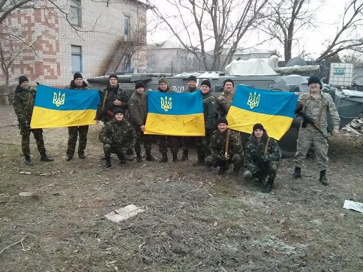Ukrainian soldiers holding a signed Ukrainian flag