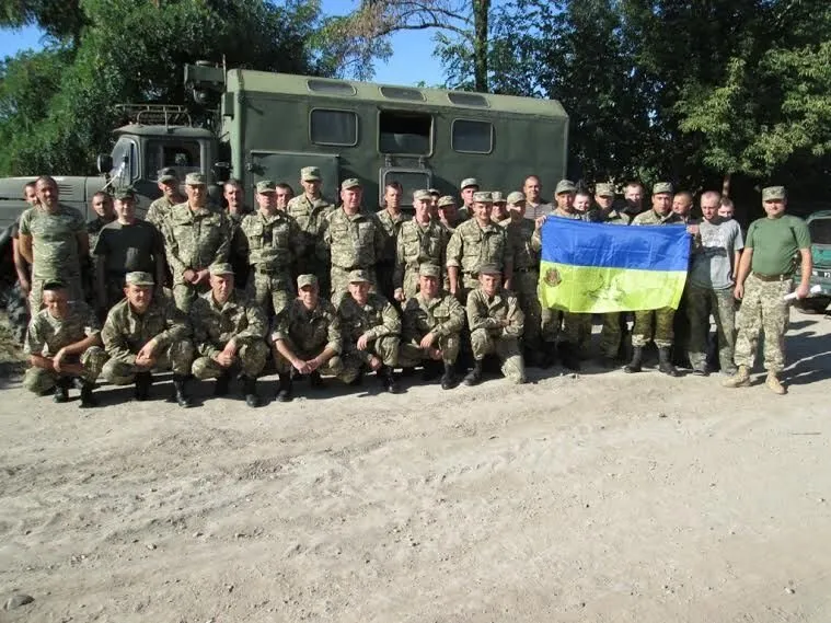 Українські військові тримають підписаний прапор України